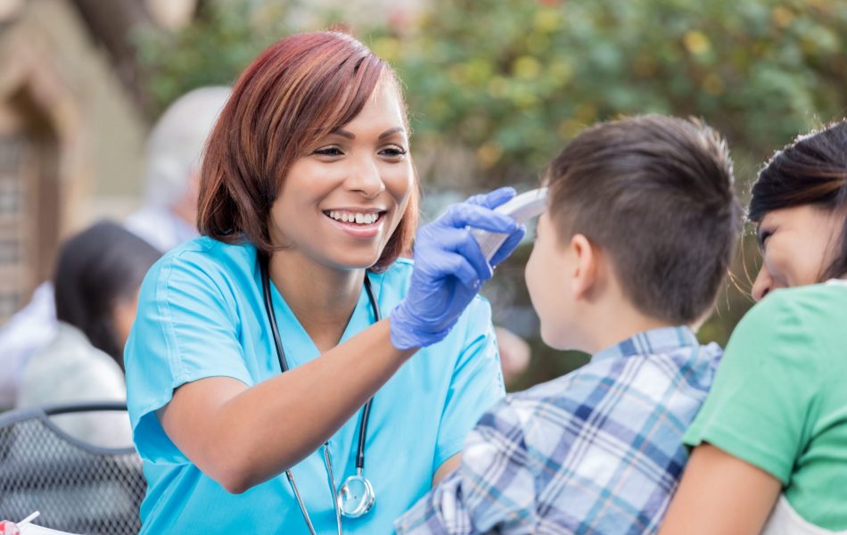 nurse taking temperature of a kid